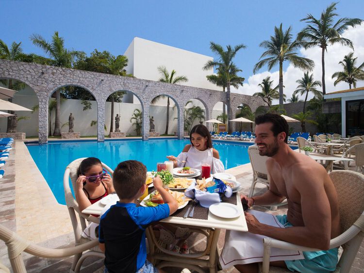 Familia disfrutando de una comida en el restaurante junto a la playa