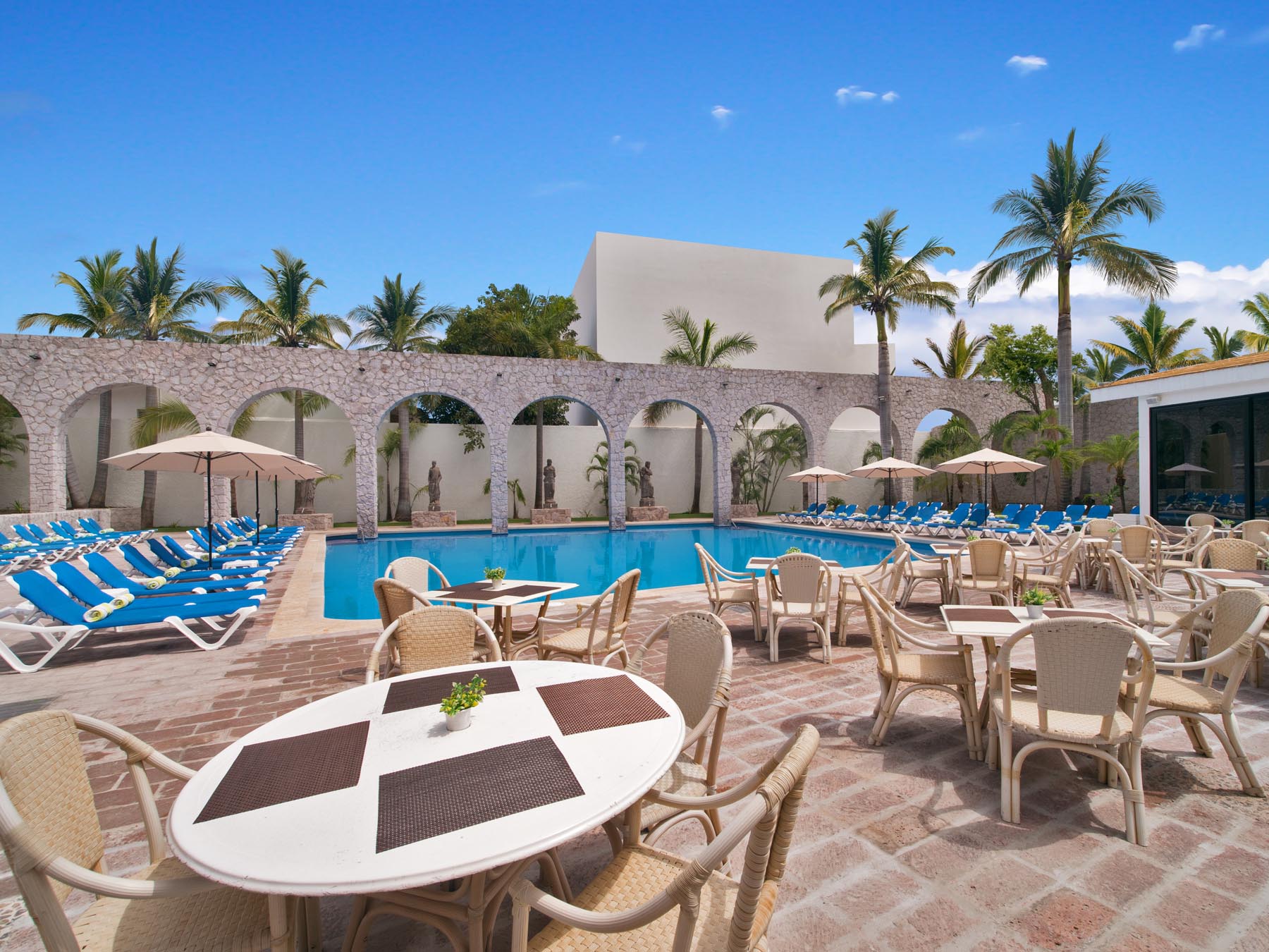 Seating area with tables and chairs beside pool
