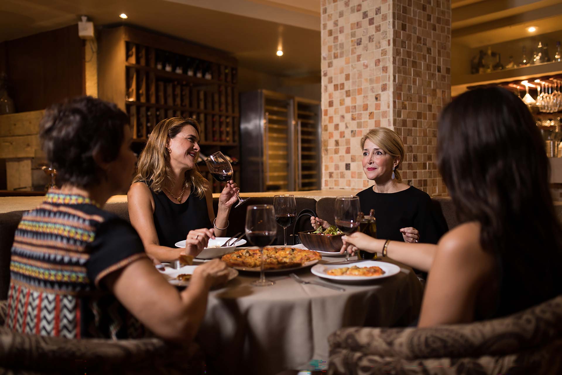 Four women eating pizza at Villa Italia